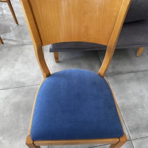 כיסא עץ עם מושב כחול על רצפת אריחים אפורה