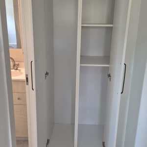 ארון פתוח עם דלתות לבנות ומדפים פנימיים