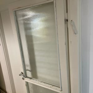 דלת עם זכוכית חלבית במסגרת עץ לבנה