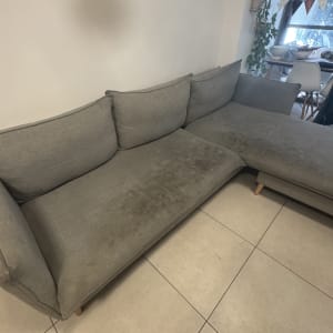 ספה אפורה עם כתמים על הרצפה