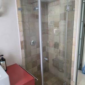 מקלחון זכוכית עם אריחים צבעוניים בחדר אמבטיה