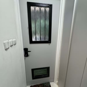 דלת אפורה עם חלון וסורג שחור