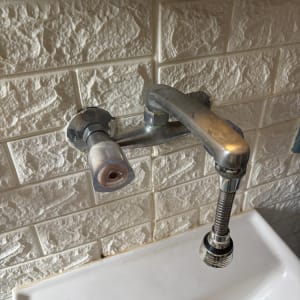 ברז מים מותקן על קיר עם כיור מתחת