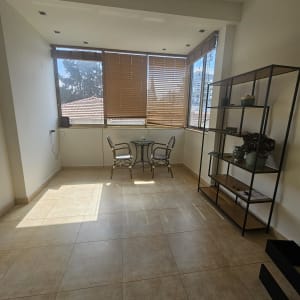 חדר עם חלונות ותריסים, שולחן וכיסאות