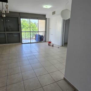 דלי צבע ומברשת על רצפת חדר ריק