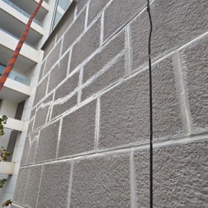 קיר בניין עם חיפוי אבן וחוט חשמל