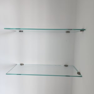 מדפי זכוכית מותקנים על קיר לבן