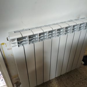 רדיאטור חימום מותקן על קיר לבן