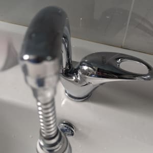 ברז וכיור עם צינור מתכת מבריק