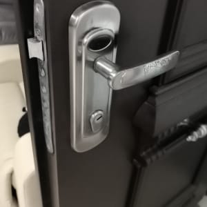 ידית דלת מתכתית עם מנעול על דלת כהה