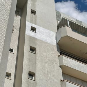 בניין גבוה עם מרפסות וחלונות קטנים