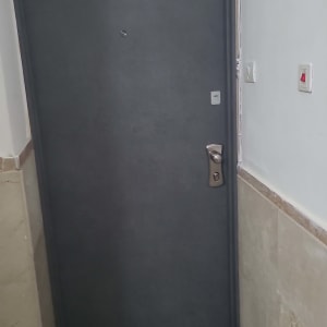 דלת מתכת כהה עם ידית כסופה