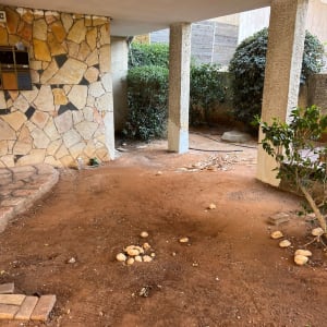 שטח חיצוני עם עמודים וקיר אבן