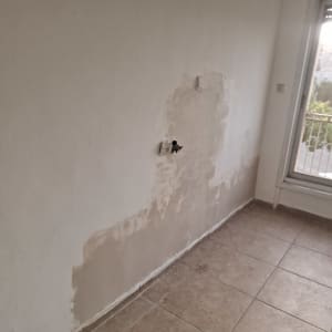 קיר עם תיקון טיח ליד חלון