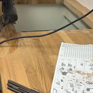 עבודת נגרות עם כלי עבודה והוראות הרכבה על שולחן עץ