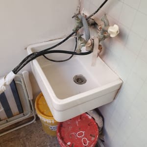 כיור עם דליים מתחת, צינורות ומחברים