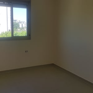 חדר ריק עם קירות צבועים בלבן וחלון