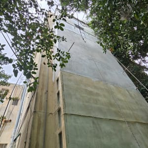 קיר בניין גבוה עם צינורות וכבלים חשמליים