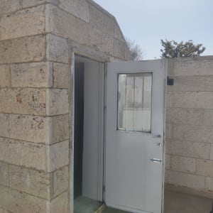 דלת פתוחה בקיר אבן עם חלון זכוכית