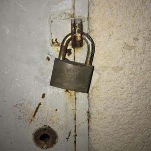 מנעול תלוי על דלת מתכת חלודה
