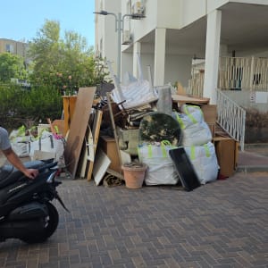 ערימת פסולת ליד בניין מגורים עם אדם על קטנוע