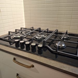 כיריים גז על משטח מטבח עם אריחי קיר לבנים