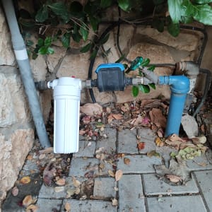 מסנן מים לבן וצינור כחול עם ברז ירוק