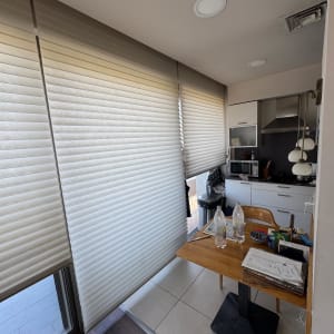 מטבח קטן עם שולחן עץ, בקבוקי פלסטיק וניירות.