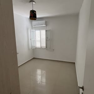 חדר ריק עם מזגן ותאורה תלויה