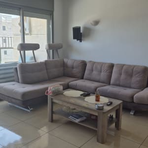 ספה אפורה עם שולחן קטן ומוצרים לניקוי