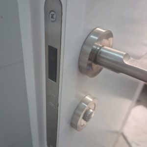 ידית דלת מתכתית עם מנעול על דלת לבנה