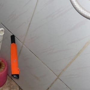 תקריב של אריחי קיר ורצפה בחדר רחצה במהלך עבודת אינסטלציה