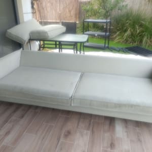 ספה בהירה על רצפת עץ במרפסת