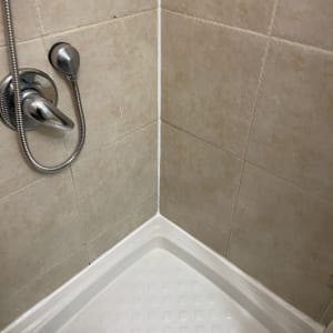 מקלחת עם אריחים חומים וברז מתכת