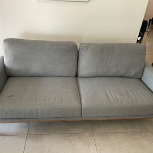 ספה אפורה עם כתם קטן על המושב