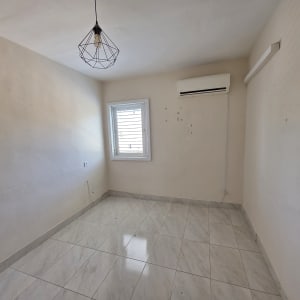 חדר ריק עם חלון ומזגן על הקיר