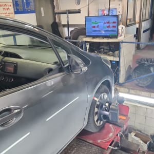 רכב על מעלית במוסך עם ציוד בדיקה ומסך מחשב