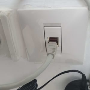 כבל רשת מחובר לשקע קיר לבן