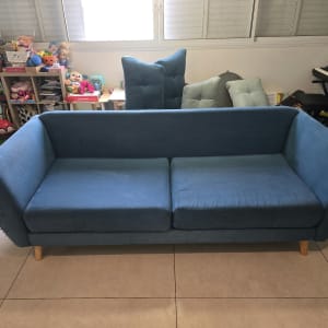 ספת בד כחולה נקייה ומטופחת לאחר ניקוי בסלון הבית