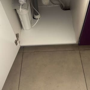 פנים ארון כיור במטבח עם תחתית מותאמת וחיבורי אינסטלציה