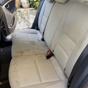 מושב רכב עם כתמים לפני ניקוי
