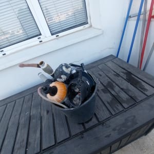 משאבה ודלי על שולחן עץ בגינה