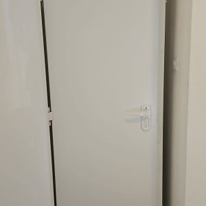 דלת לבנה עם ידית בחדר קטן