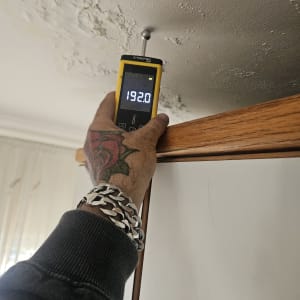 מד לחות נוגע בתקרה עם סימני רטיבות