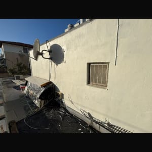 צלחת לוויין מותקנת על קיר חיצוני עם כבלים