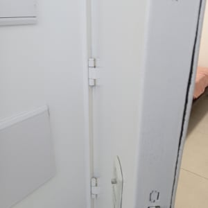 דלת לבנה עם מנעול ובריח מתכת