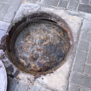 פתח ביוב פתוח על מדרכה מרוצפת