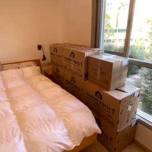 ארגזים מסודרים ליד מיטה בחדר שינה