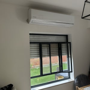 מזגן מותקן על קיר מעל חלון פתוח