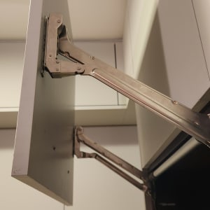 מנגנון פתיחה של ארון מטבח עם צירים מתכתיים